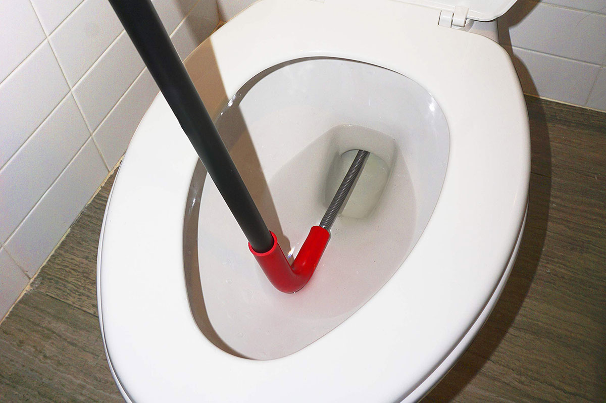 Unblocking a toilet with a snake